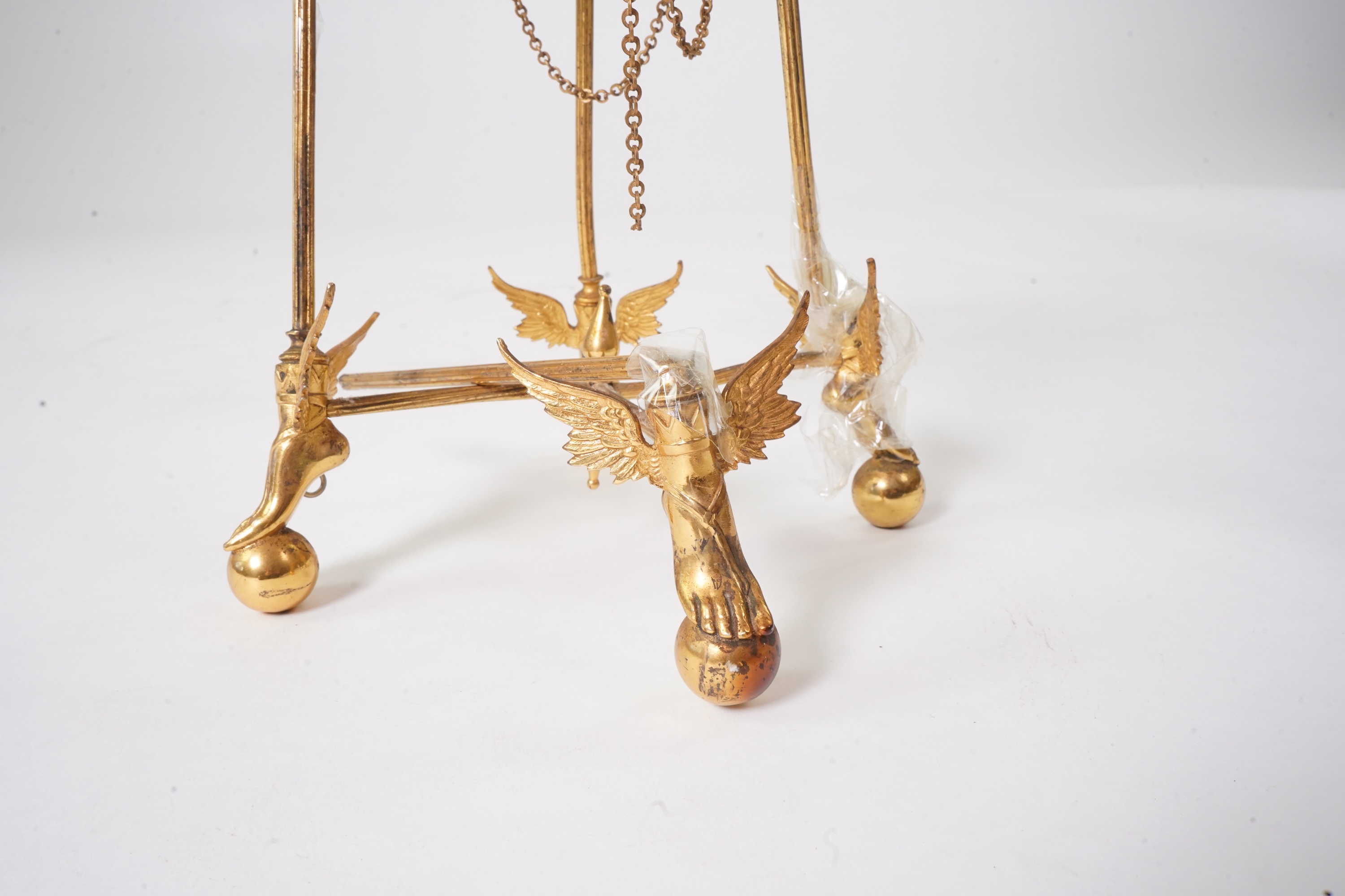 An unusual enamel and gilt brass timepiece, pendant from gilt brass frame, stand 26cm high. Condition - dismantled